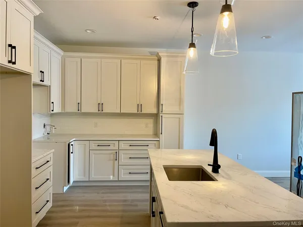 a kitchen with granite countertop white cabinets and a sink