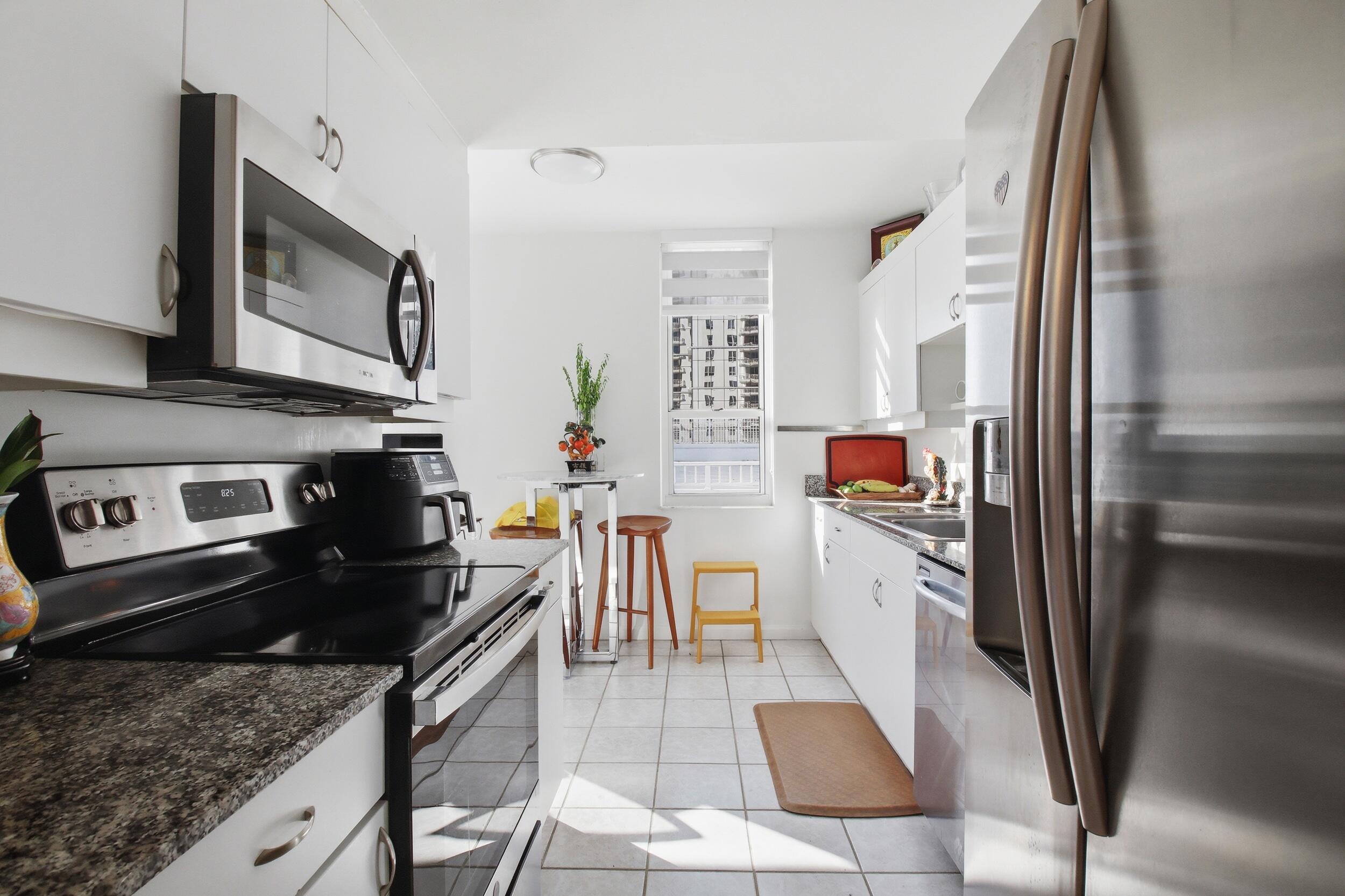 701 Brickell Key Boulevard, Unit 610 Miami, FL 33131 - Photo 14 of 40 a kitchen with stainless steel appliances granite countertop a refrigerator stove top oven and sink