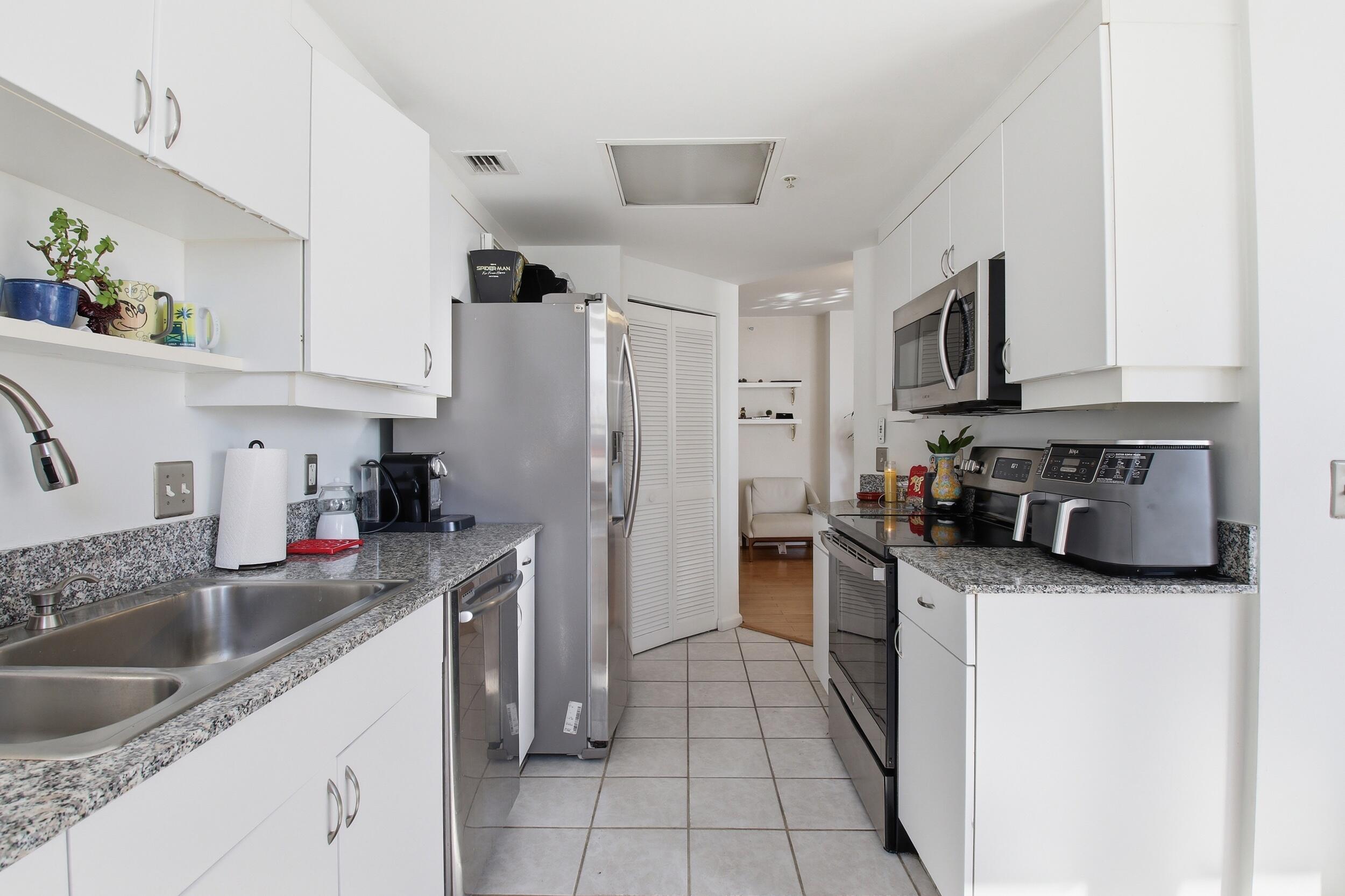 701 Brickell Key Boulevard, Unit 610 Miami, FL 33131 - Photo 16 of 40 a kitchen with stainless steel appliances granite countertop a sink stove and refrigerator