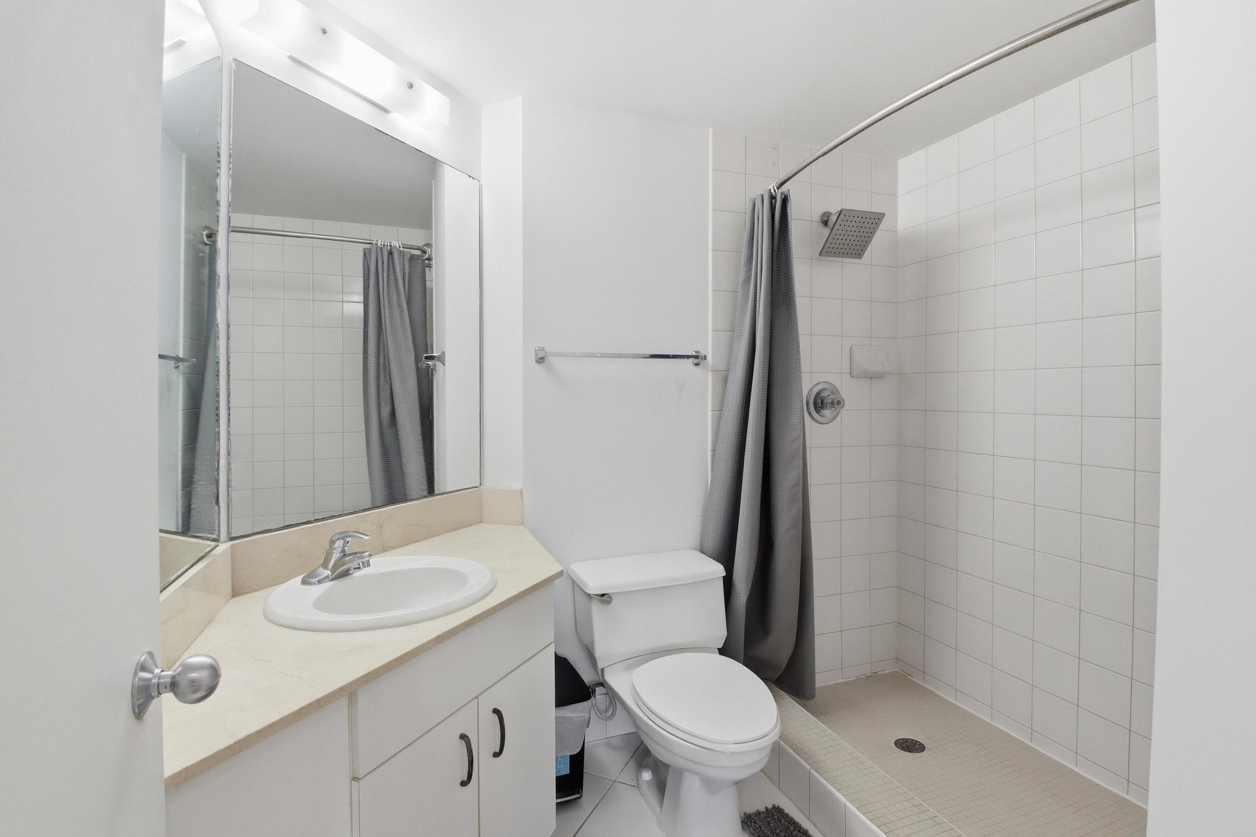 701 Brickell Key Boulevard, Unit 610 Miami, FL 33131 - Photo 18 of 40 a bathroom with a granite countertop sink toilet and shower