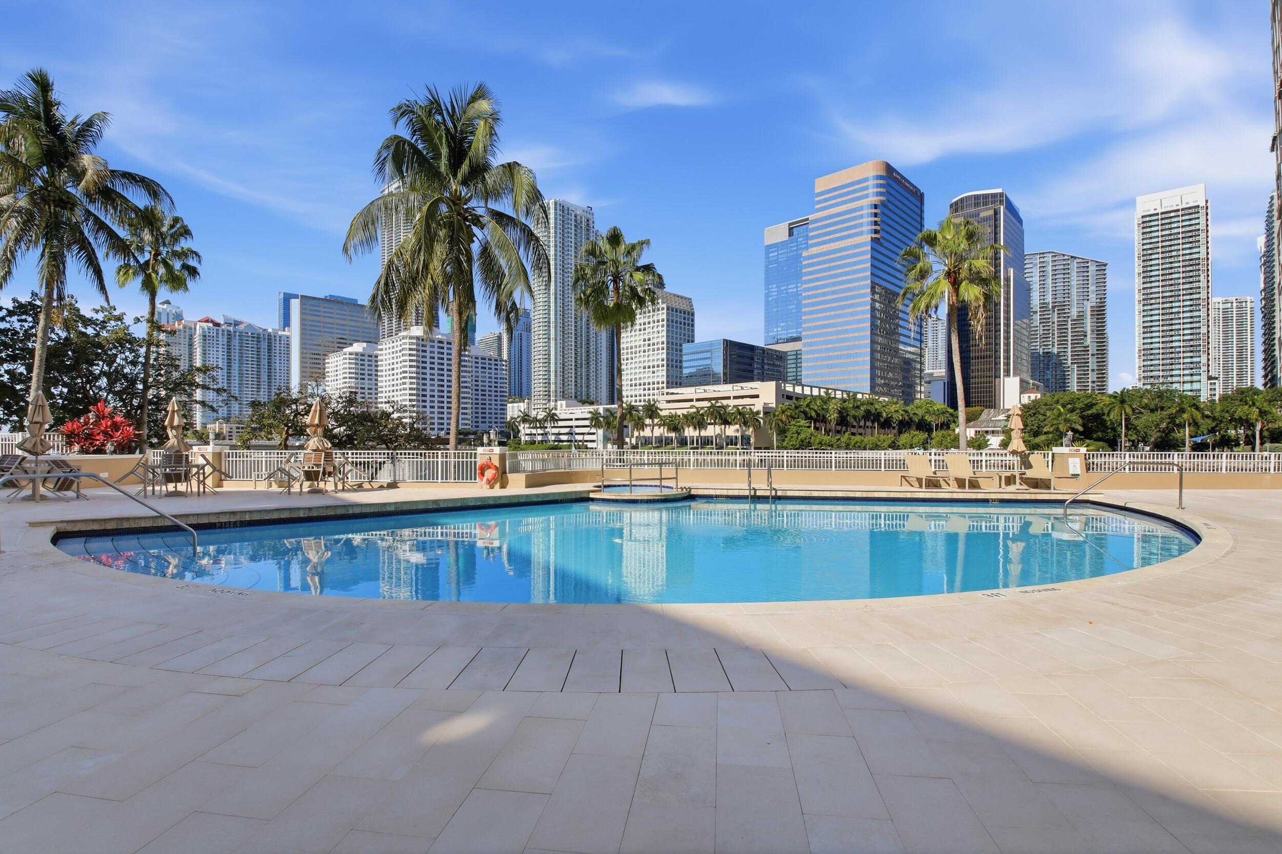 701 Brickell Key Boulevard, Unit 610 Miami, FL 33131 - Photo 39 of 40 a view of a swimming pool with a lawn chairs and palm tree