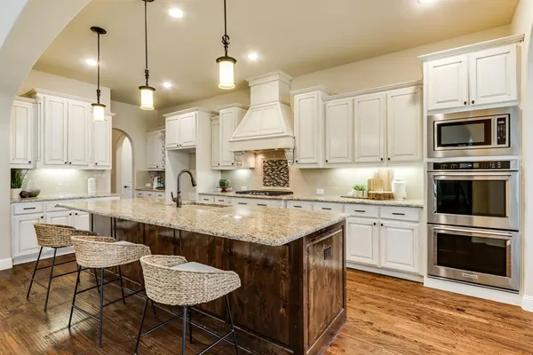 a kitchen with stainless steel appliances granite countertop a stove a sink island and a refrigerator