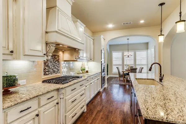 a kitchen with sink stove and cabinets