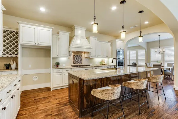 a large kitchen with kitchen island a dining table and chairs