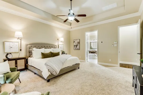 a spacious bedroom with a bed and a chandelier