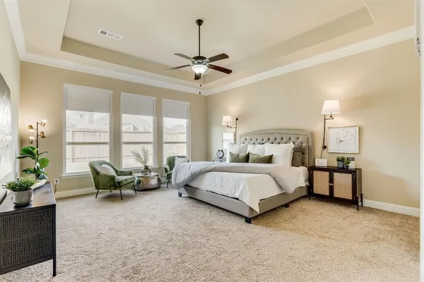 a spacious bedroom with a bed and large windows