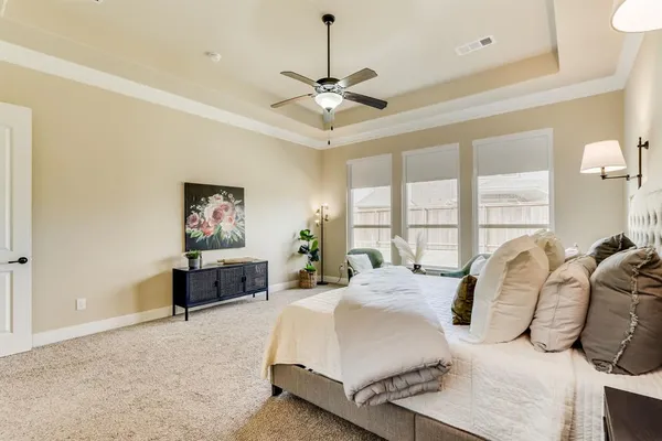 a spacious bedroom with a bed a dresser and large window