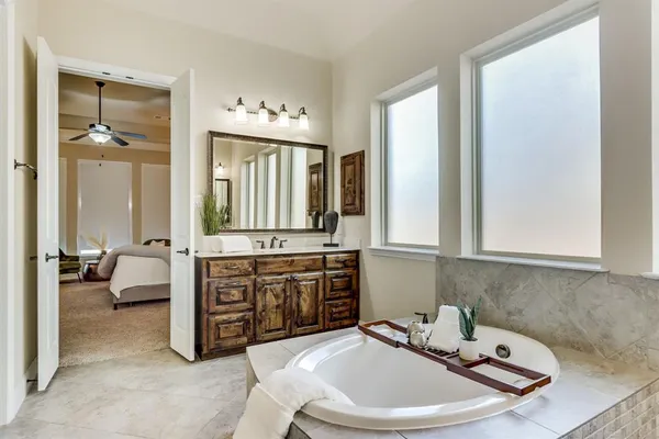 a bathroom with a tub a sink and mirrors