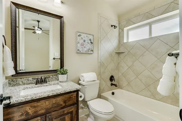 a bathroom with a granite countertop sink toilet and shower