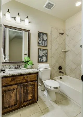 a bathroom with a granite countertop toilet a sink and a mirror