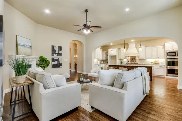 a living room with furniture and a view of kitchen