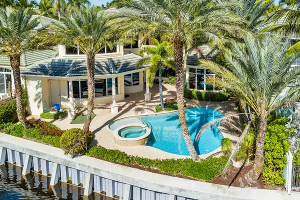 a view of a house with backyard sitting area and swimming pool