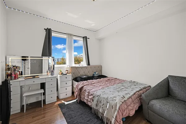 a bedroom with a bed and wooden floor