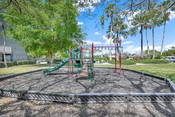 a view of a park with swings and a trees