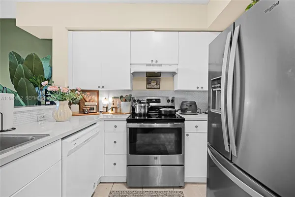 a kitchen with stainless steel appliances white cabinets and a sink