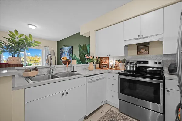 a kitchen with appliances a sink and cabinets