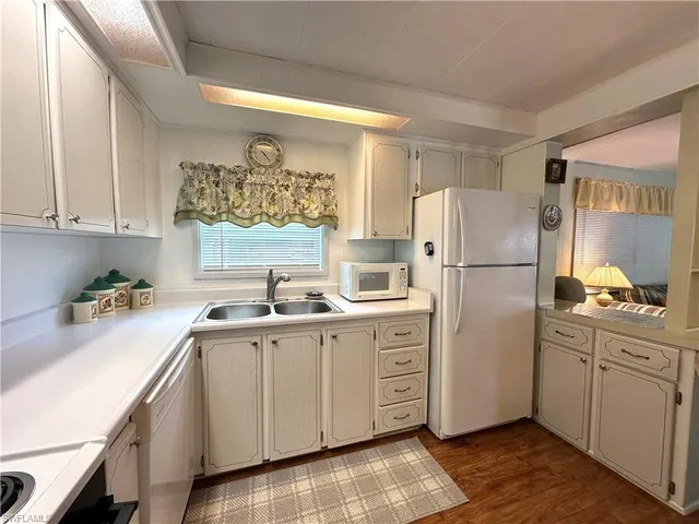 a very nice looking kitchen with granite countertop a stove and white cabinets