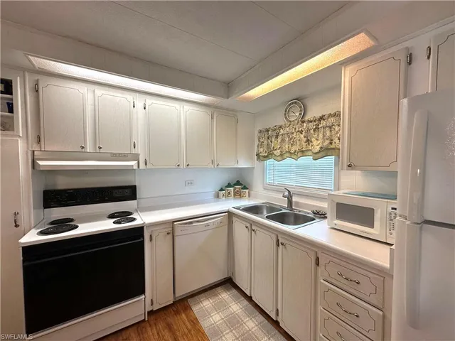 a kitchen with a sink a refrigerator a washer and dryer