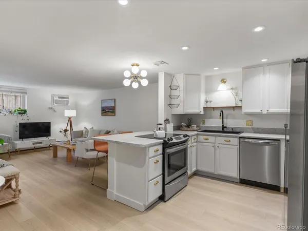 a kitchen with granite countertop a sink and white cabinets