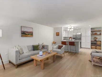 a living room with furniture and view of kitchen