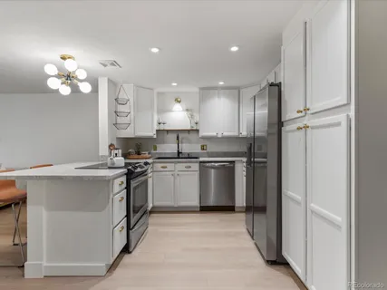 a kitchen with a sink stainless steel appliances cabinets and a window