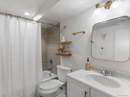 a bathroom with a sink a toilet and shower curtain