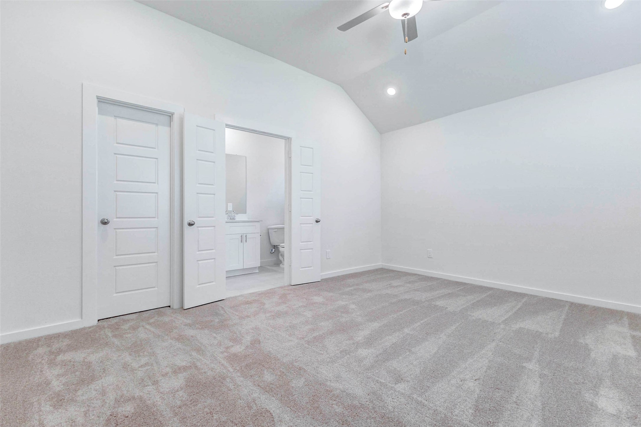 6475 Escondido Drive Rosharon, TX 77583 - Photo 17 of 32 The open-concept layout continues with a bright living area that flows directly into the kitchen and main gathering spaces. Soft carpet, tall ceilings, recessed lighting, and clean white walls create a spacious and flexible setting, while the nearby room access adds convenience for everyday living.