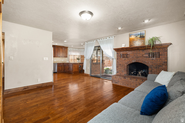 892 Cambridge Drive St. George, UT 84770 - Photo 21 of 65 Open concept living area featuring wood-finish flooring, a brick fireplace with mantel, and recessed lighting