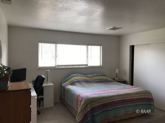 1237 West Iowa Avenue Ridgecrest, CA 93555 - Photo 14 of 20 a bedroom with a bed and a window