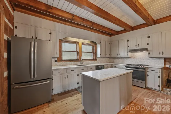 a kitchen with a table chairs refrigerator and cabinets