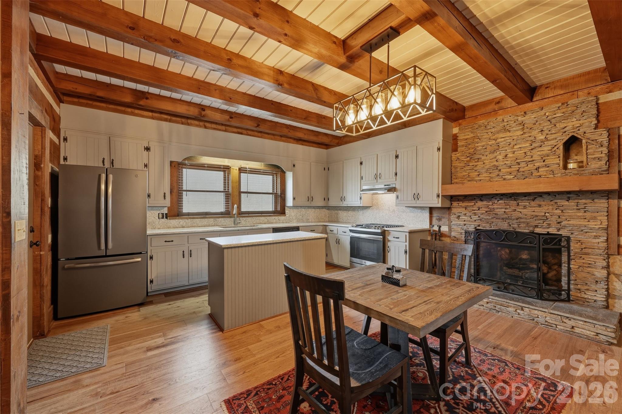 2255 Mt Olive Church Road Newton, NC 28658 - Photo 11 of 43 a kitchen with a table chairs refrigerator and cabinets