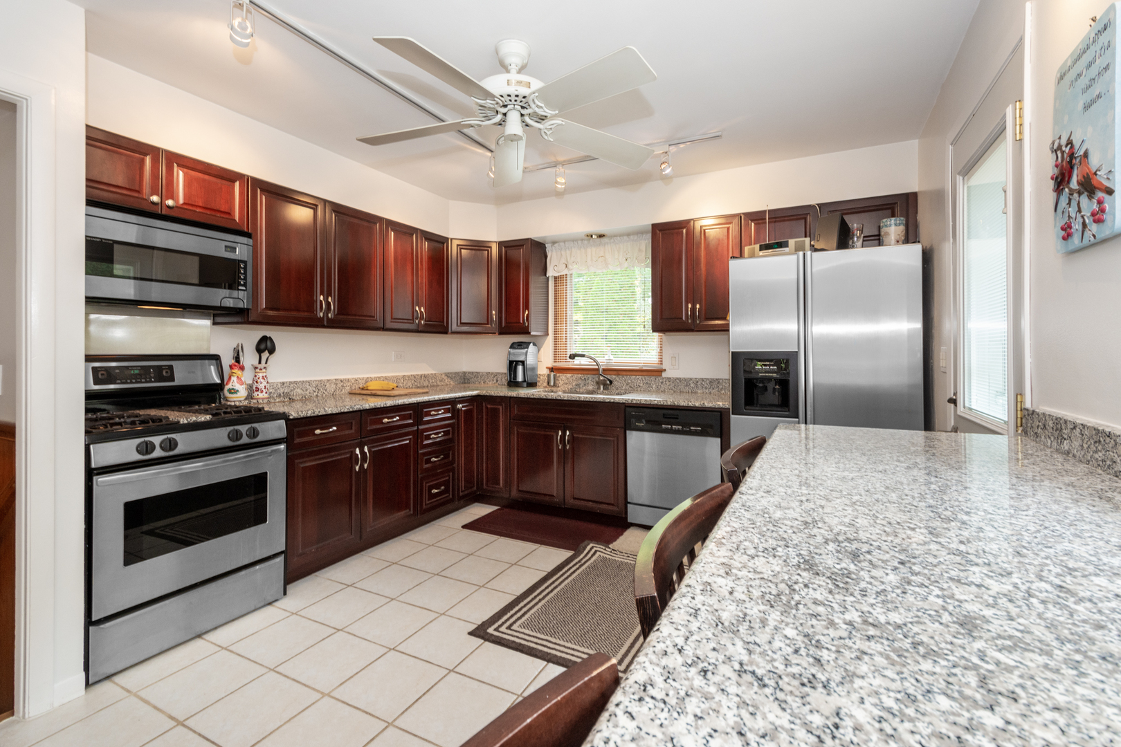 1420 Lee Road Northbrook, IL 60062 - Photo 10 of 36 a large kitchen with stainless steel appliances kitchen island granite countertop a stove a sink dishwasher and a refrigerator with wooden cabinets