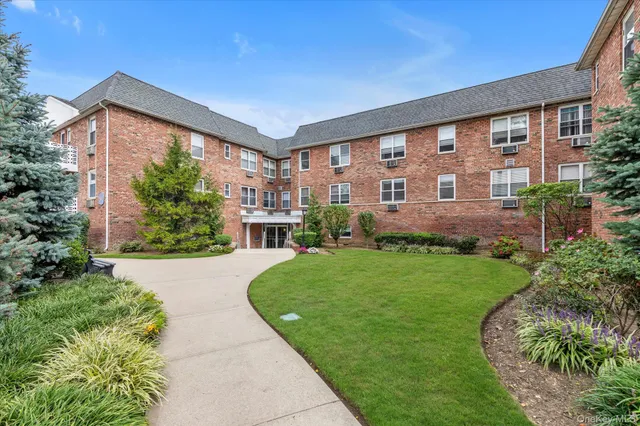 a front view of a house with a yard and potted plants