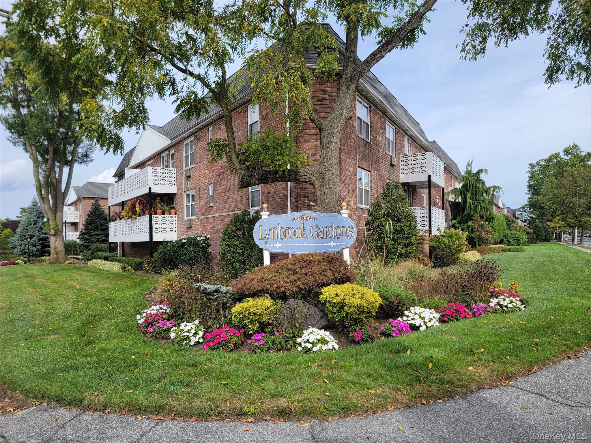 2 Fowler Avenue, Unit 228 Lynbrook, NY 11563 - Photo 2 of 18 a bunch of flowers in front of the house