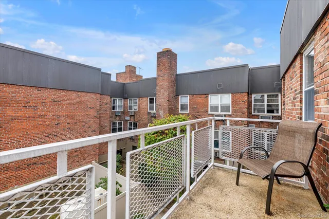 a view of a chair and tables in the balcony