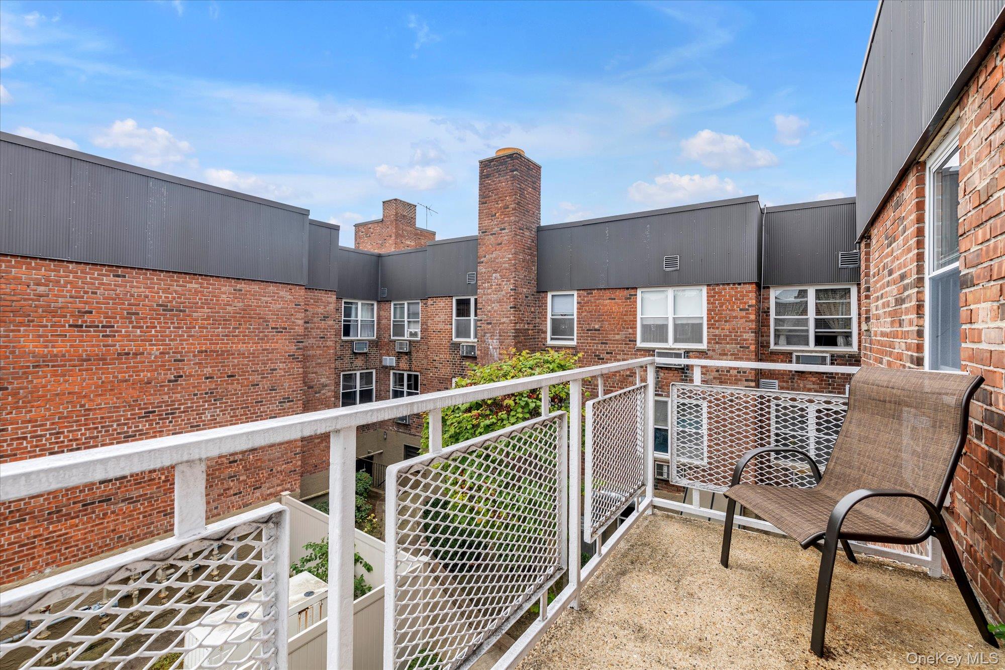 2 Fowler Avenue, Unit 228 Lynbrook, NY 11563 - Photo 9 of 18 a view of a chair and tables in the balcony
