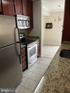 a kitchen with granite countertop a stove a microwave a sink and a refrigerator