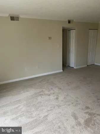 a view of a hallway with wooden floor and a bathroom