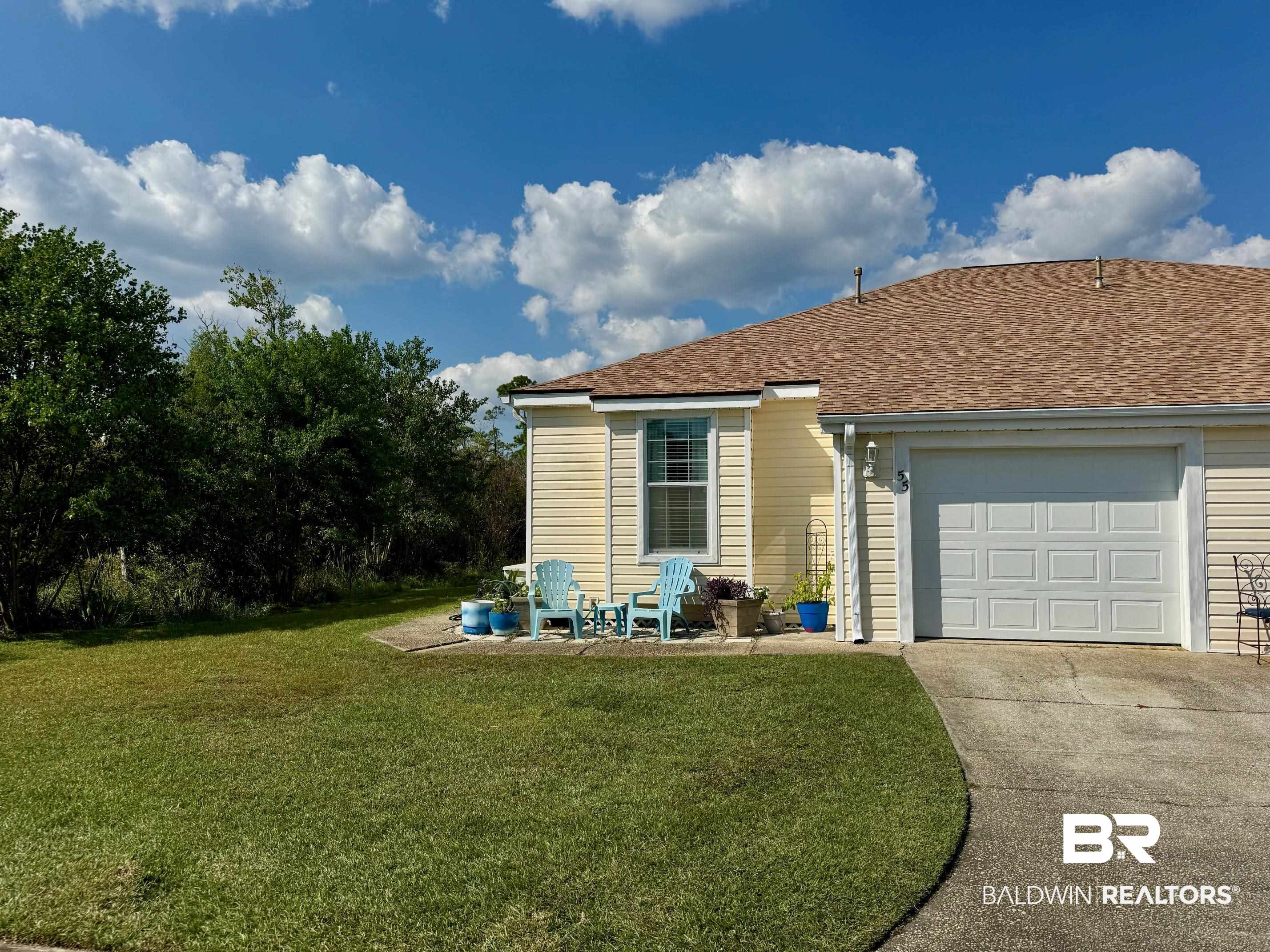 3200 Loop Road, Unit 55 Orange Beach, AL 36561 - Photo 28 of 40 View of side of home featuring a garage and a lawn