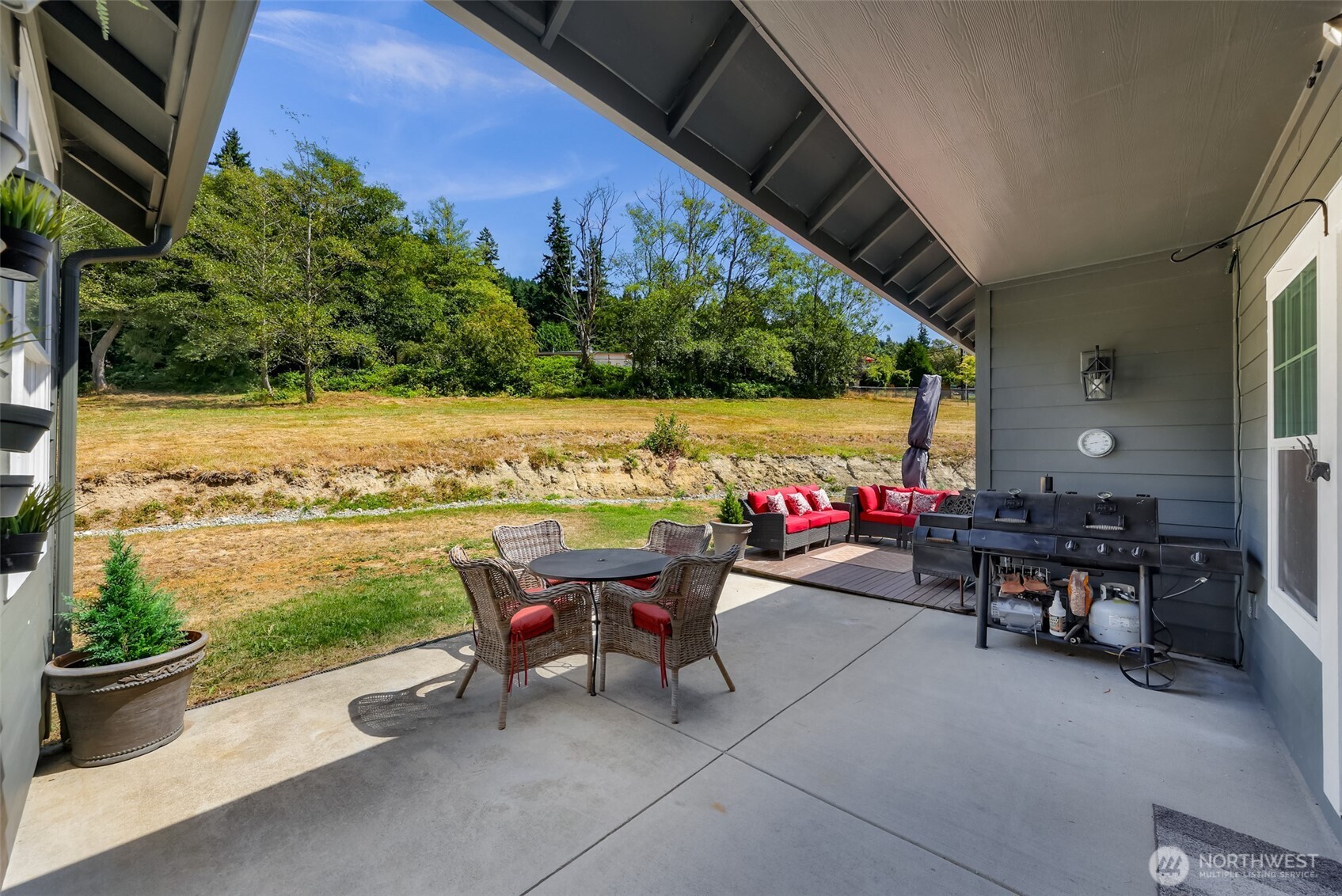 19727 Skyridge Road Mount Vernon, WA 98274 - Photo 10 of 32 a view of a patio with table and chairs potted plants with wooden floor and fence