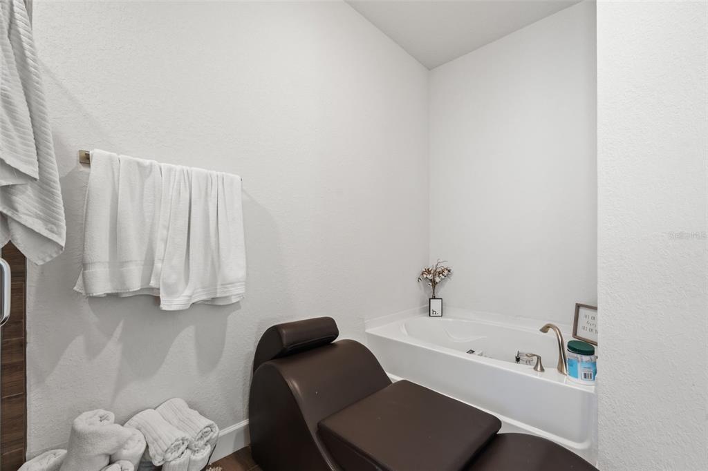 199 Bittern Loop Inverness, FL 34453 - Photo 21 of 36 a bathroom with a bathtub a sink and a chair