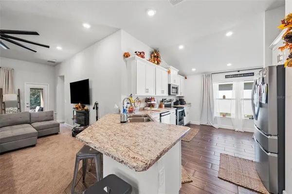a kitchen with granite countertop white cabinets and stainless steel appliances