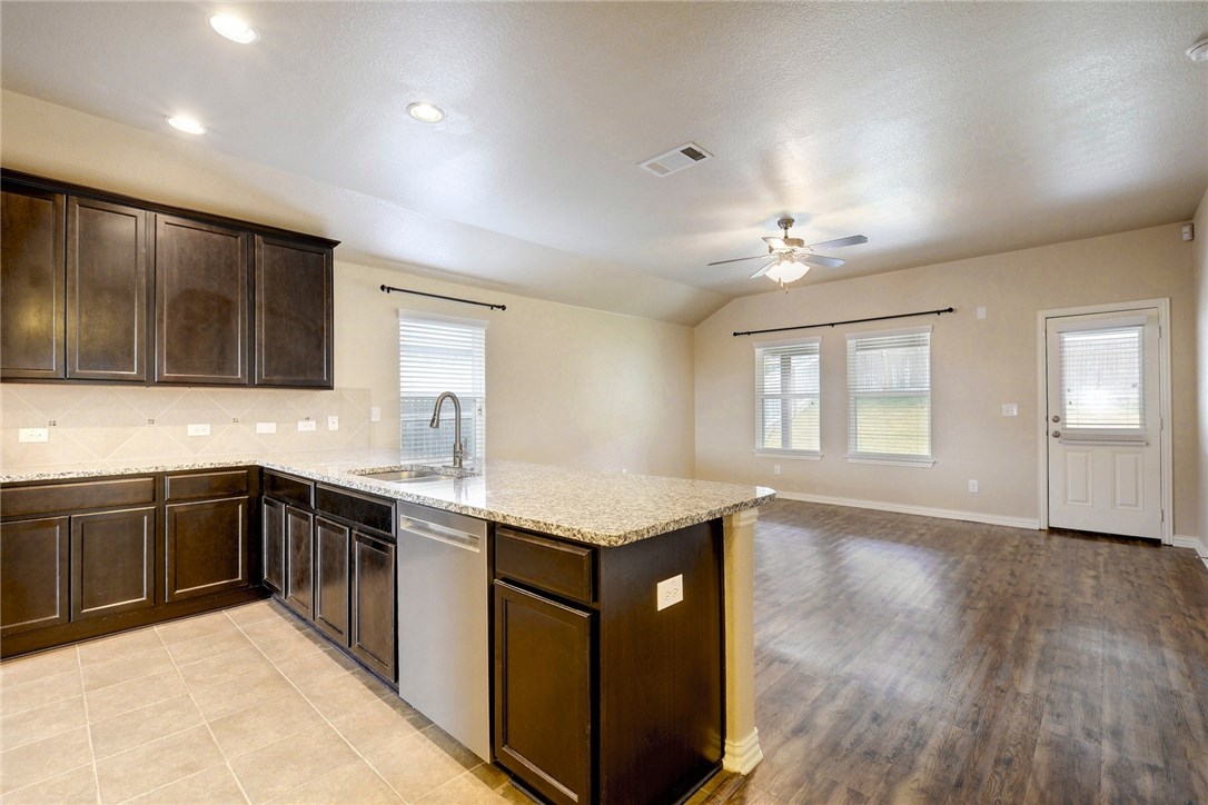 3621 Rams Horn Way Round Rock, TX 78665 - Photo 2 of 24 a kitchen with a sink a window and wooden cabinets