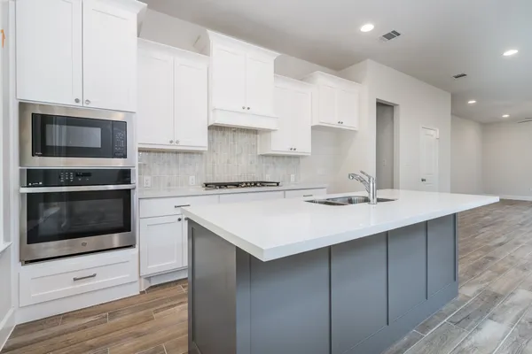 a kitchen with stainless steel appliances a stove a sink and a microwave