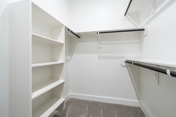 a view of walk in closet with empty racks