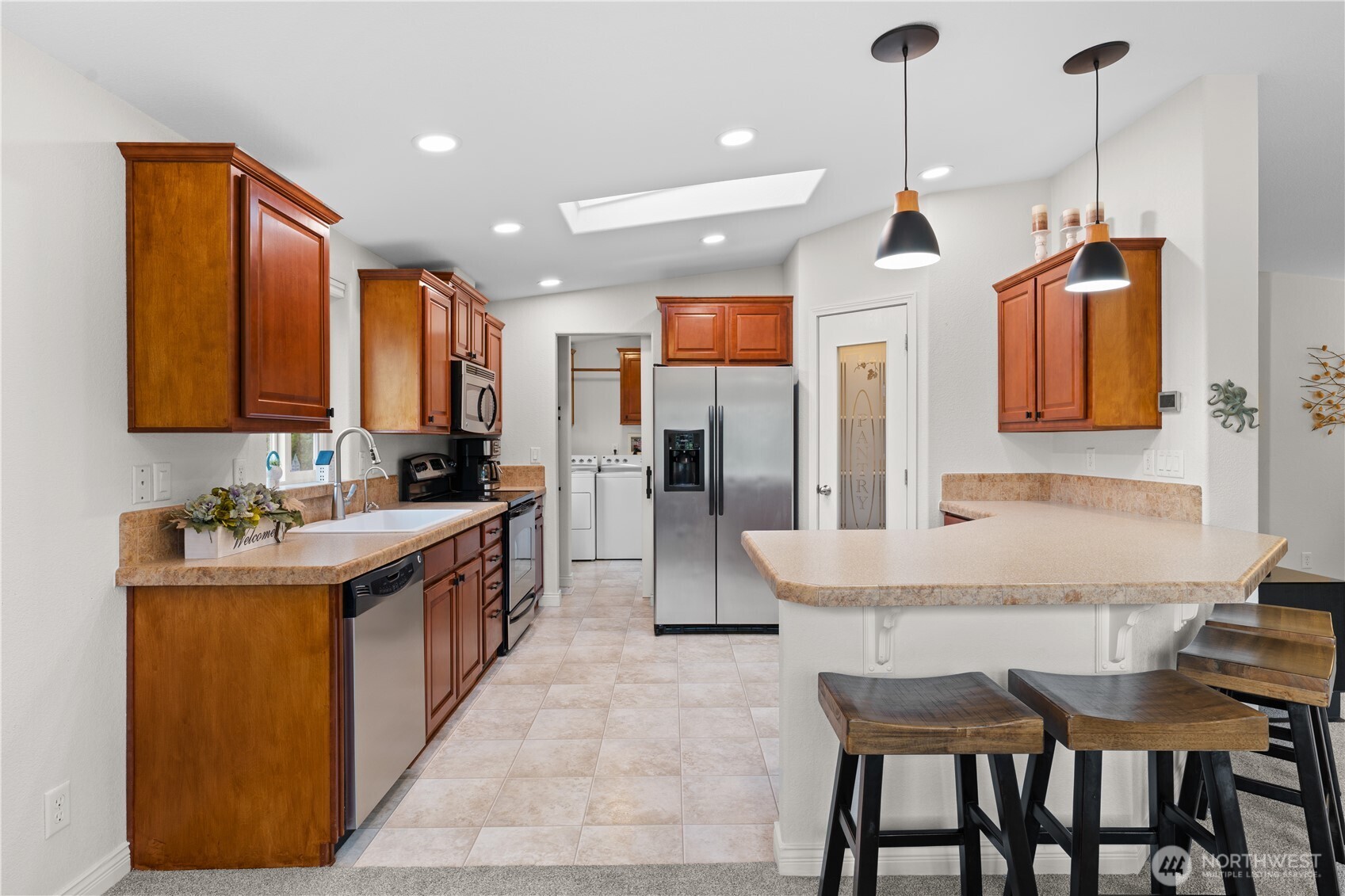 23825 15th Avenue Southeast, Unit 427 Bothell, WA 98021 - Photo 9 of 38 a kitchen with kitchen island granite countertop a sink and refrigerator
