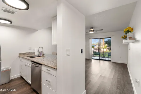 a kitchen with a sink and wooden floor