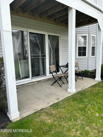 a view of backyard with a chair and table in the patio