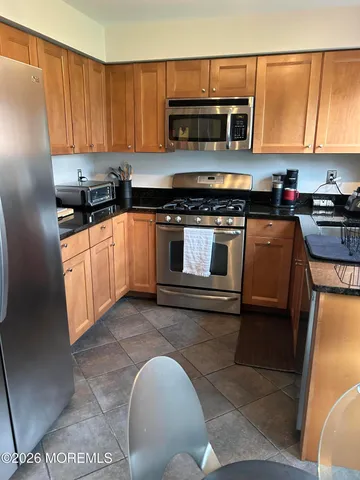 a kitchen with stainless steel appliances granite countertop a stove a microwave and a sink