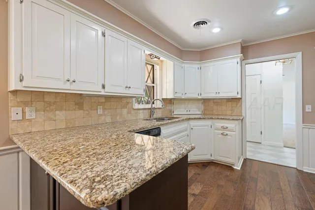 a kitchen with a window a sink and cabinets
